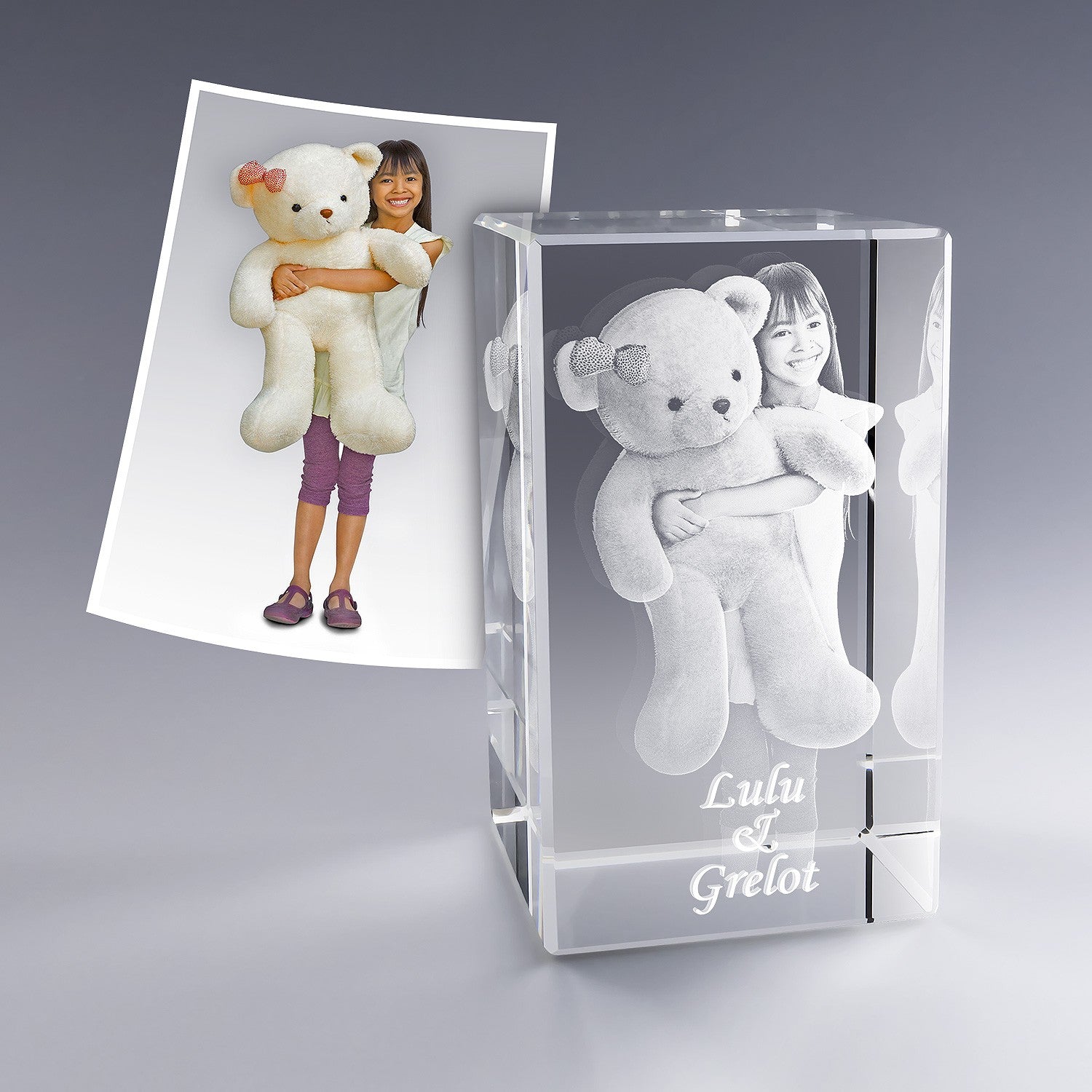 Bloc de cristal vertical avec gravure d’une petite fille tenant un gros ours en peluche. L’expression rayonnante de l’enfant et le doudou gravés en 3D en font un cadeau tendre et inoubliable, accompagné du texte personnalisé "Lulu & Grelot".