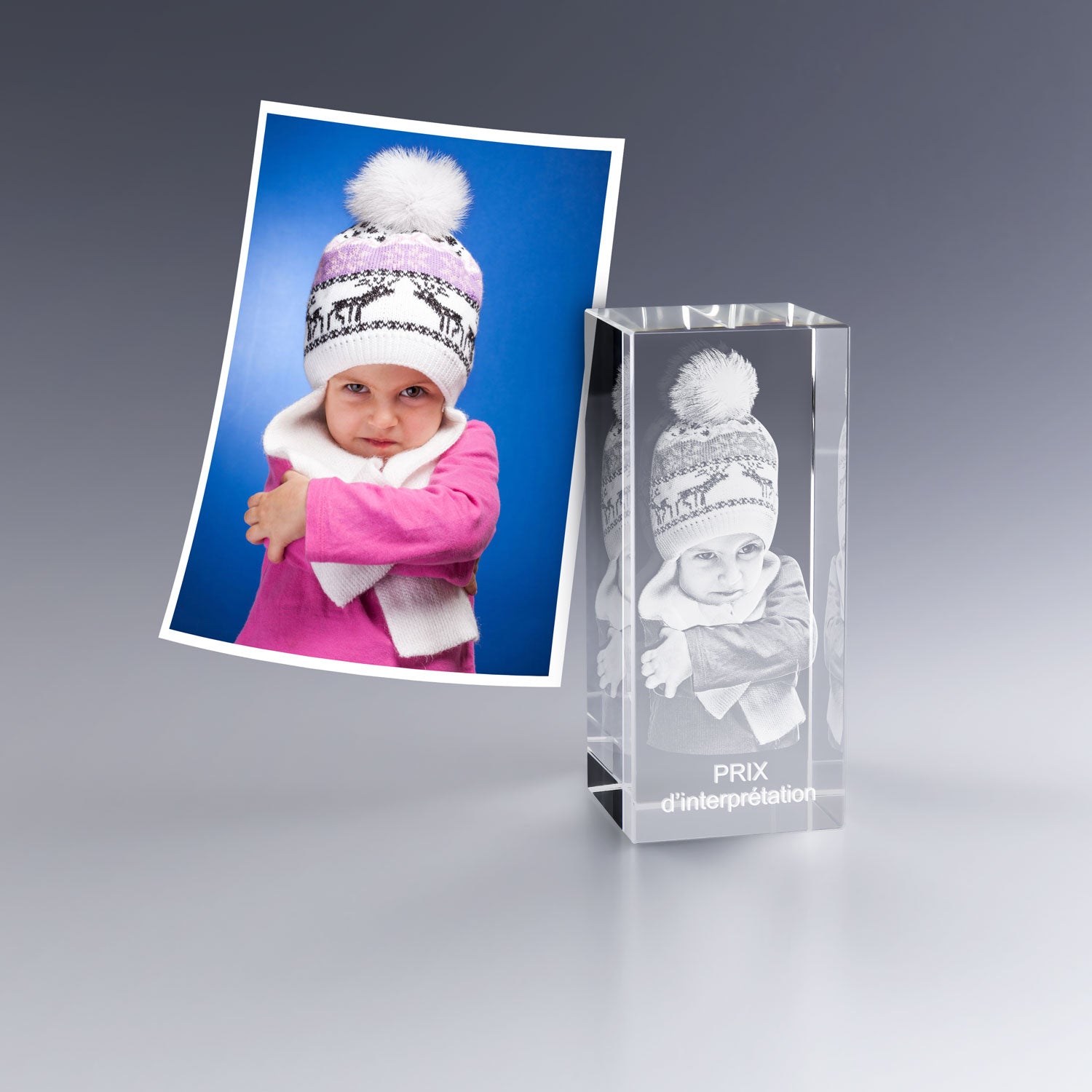 Gravure laser 3D dans un bloc en verre haut représentant une enfant pleine d'expression, idéale pour offrir un “Prix d’interprétation” ou comme souvenir humoristique et affectueux. Cadeau unique et personnalisable à exposer dans une vitrine ou un bureau.