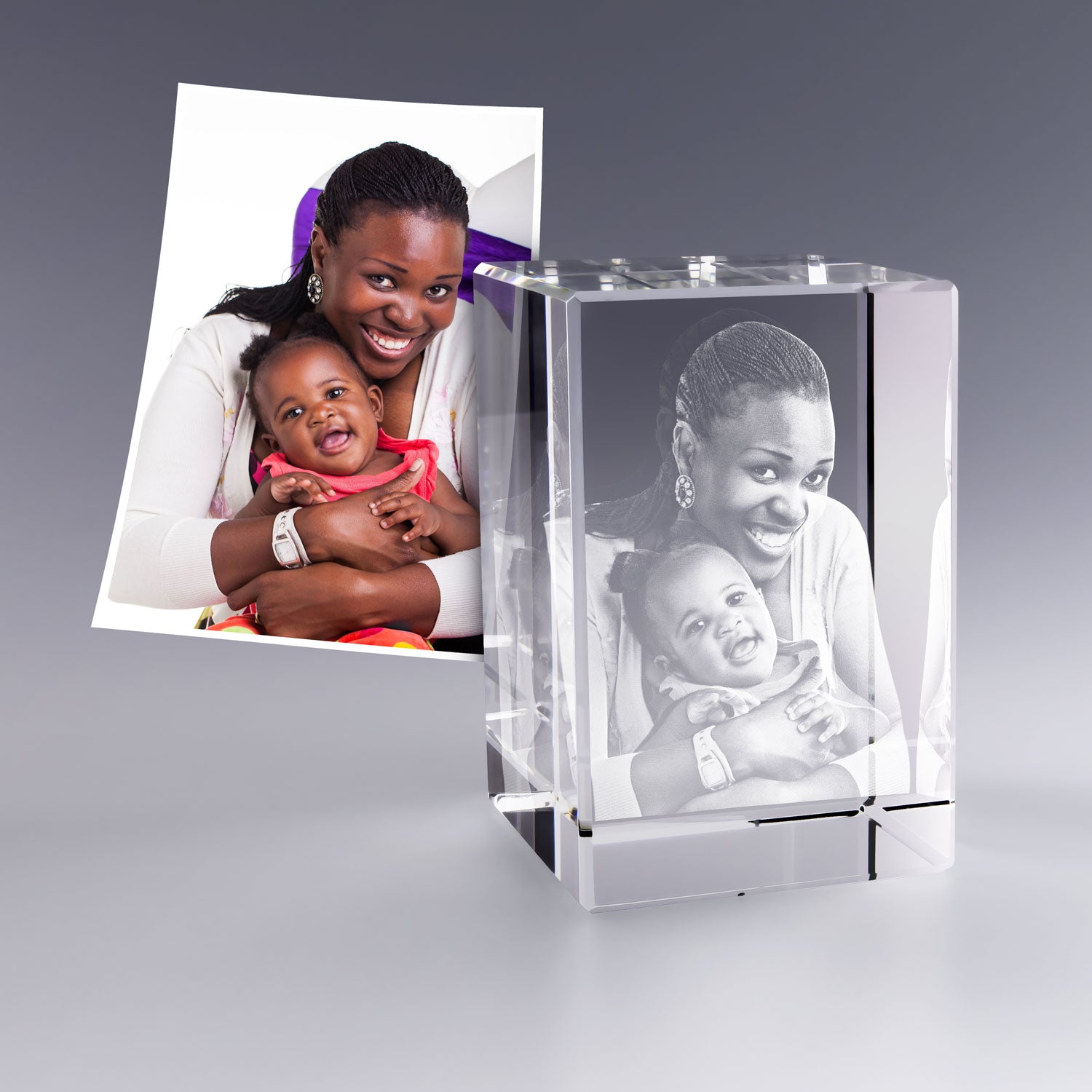 Bloc en verre gravé en 3D représentant une mère et son bébé souriant dans ses bras. La gravure laser restitue chaque détail de leur complicité avec une grande précision. Cadeau personnalisé idéal pour une naissance ou la fête des mères.