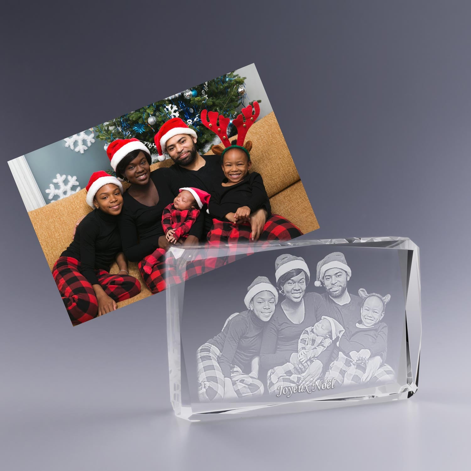 Bloc en verre horizontal facetté avec gravure 2D d’une famille en pyjama de Noël, tous souriants, gravé avec "Joyeux Noël" et présenté à côté de la photo originale en couleur.