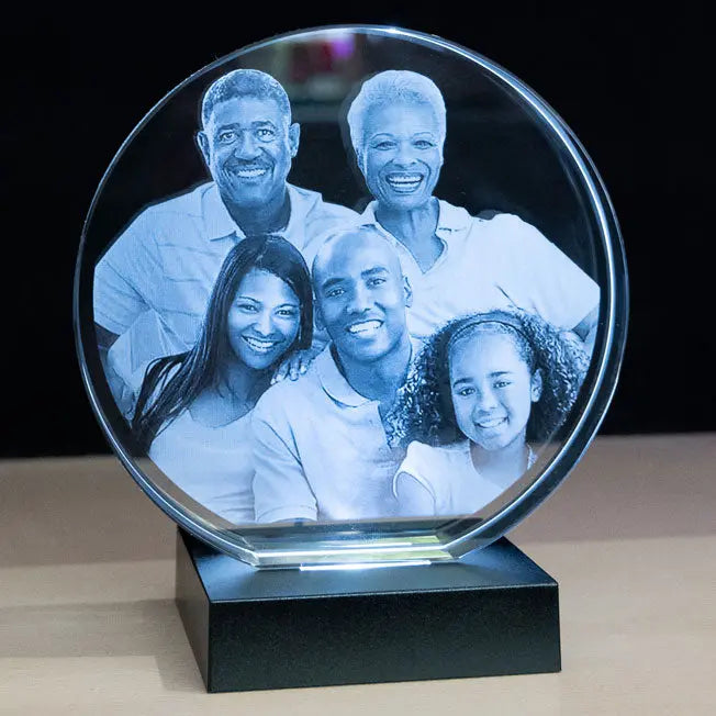 Bloc rond gravé en verre avec photo de famille, présenté sur socle à LED. Cadeau personnalisé à offrir pour les grandes occasions ou la décoration maison.