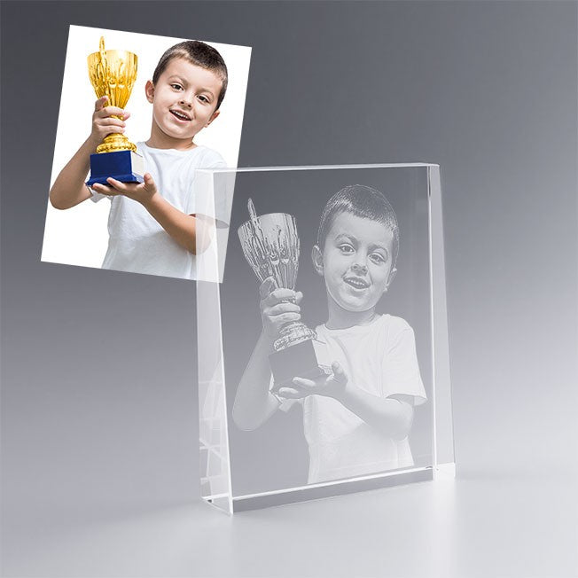 Gravure 2D dans un bloc trapèze en verre représentant un enfant fier avec sa coupe. Un cadeau personnalisé idéal pour féliciter un exploit ou une victoire.