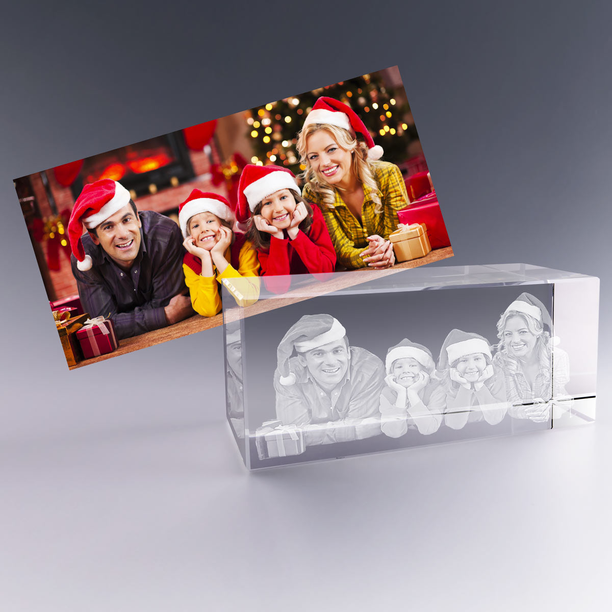 Grand Bloc en Verre Horizontal 3D avec photo gravée – Cadeau de Noël personnalisé – Une famille souriante coiffée de bonnets rouges pose devant un décor festif. Leur photo est magnifiquement transformée en gravure 3D dans un bloc en verre de 18 cm, un cadeau personnalisé haut de gamme livré dans un coffret élégant pour célébrer Noël avec émotion.