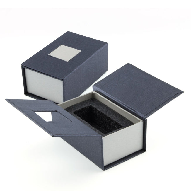 Boîte rigide noire et grise avec mousse de protection intérieure, conçue pour accueillir un bloc en verre gravé de petit format.