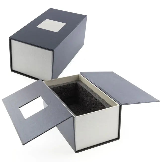 Boîte rigide noire et grise avec fenêtre carrée et mousse de calage, conçue pour protéger un bloc en verre gravé en 3D de format vertical ou horizontal.
