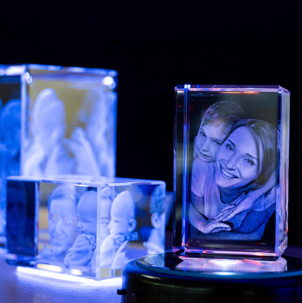 Blocs en verre personnalisés avec gravure photo 3D éclairés par socle lumineux, parfaits pour un cadeau personnalisé en boutique Zephyr Paris.