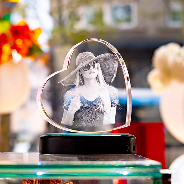 Bloc cœur en verre gravé 3D avec portrait de femme à partir d'une photo. Cadeau personnalisé lumineux, exposé en vitrine Zephyr Paris.