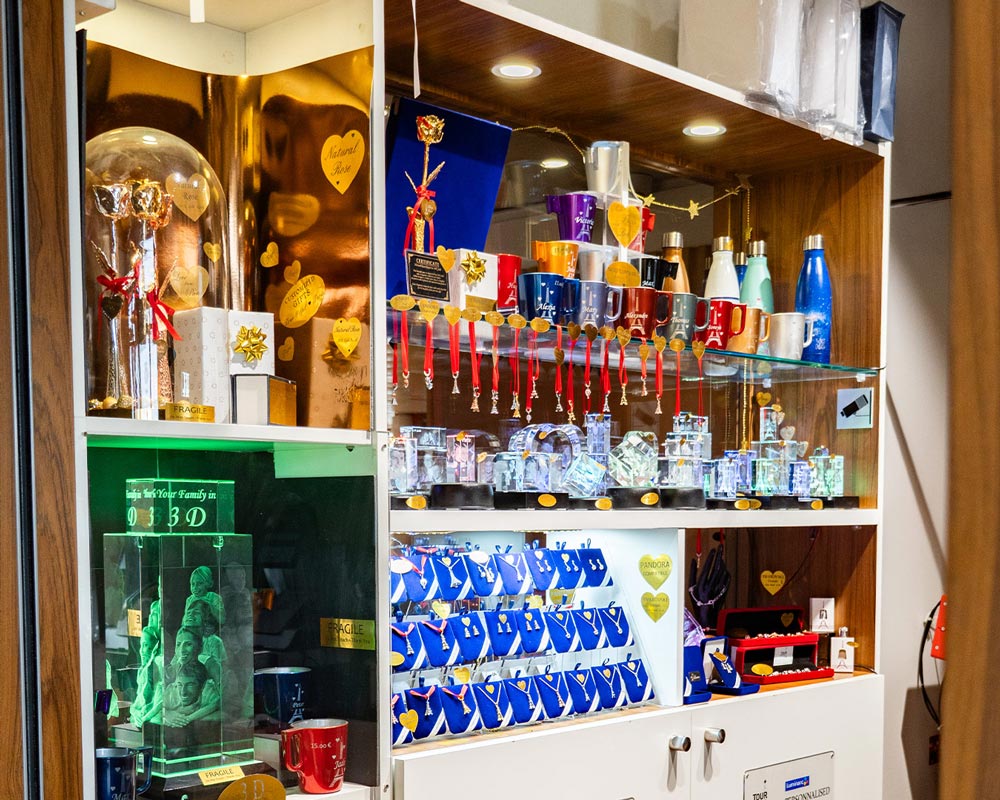 Vitrine de la boutique Zephyr à la Tour Eiffel avec cadeaux personnalisés : mugs gravés, bouteilles isothermes, blocs en verre 3D et bijoux.