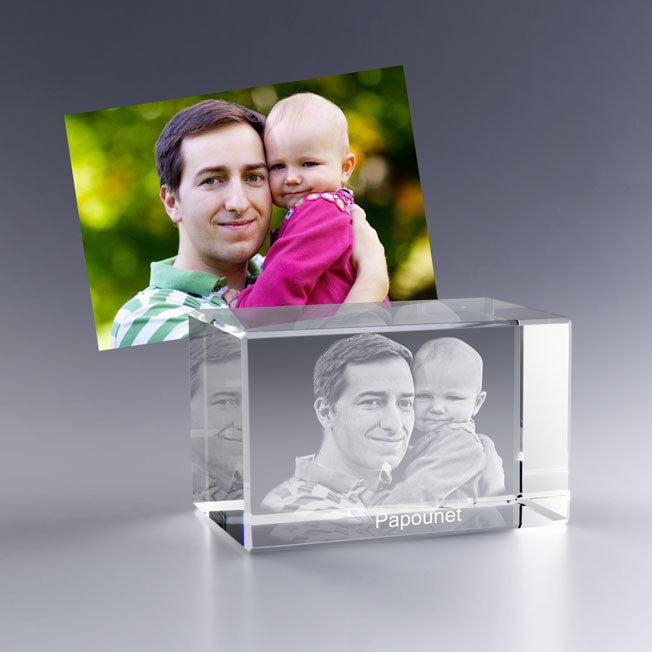 Bloc en verre gravé en 3D avec le portrait d’un père tenant son enfant dans les bras, avec l’inscription “Papounet”, inspiré d’une photo souvenir.