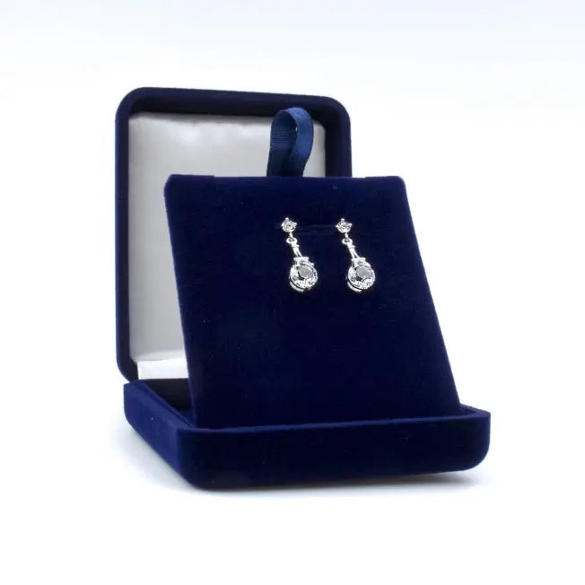 Boucles d’oreilles argentées avec pendentif Tour Eiffel et cristaux Swarovski®, présentées dans un écrin personnalisable pour un cadeau raffiné.