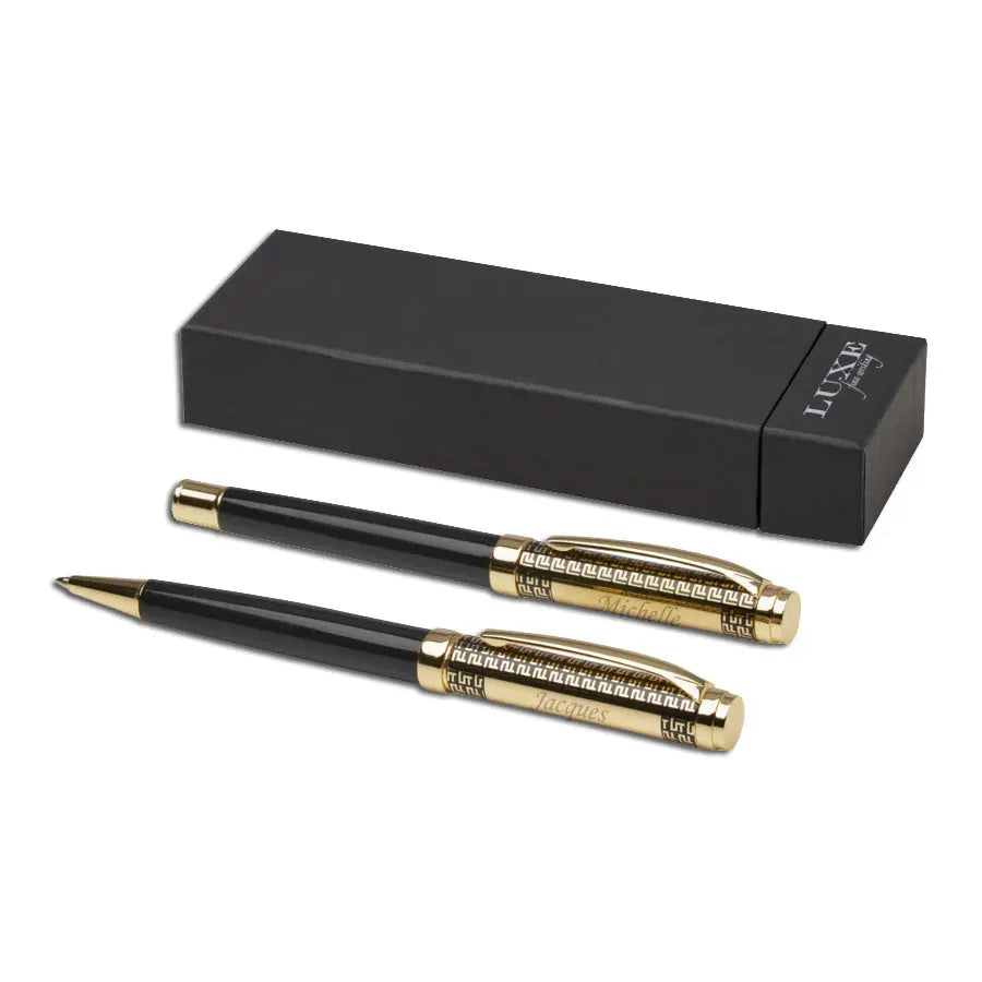 Stylo bille et stylo roller noirs et dorés présentés devant un étui cadeau noir LUXE, parfaits pour un cadeau raffiné.