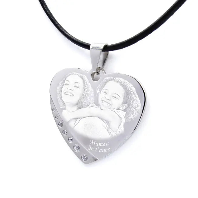 Pendentif cœur gravé avec une maman et sa fille. Message “Maman je t’aime” et finition strass pour un cadeau émouvant.