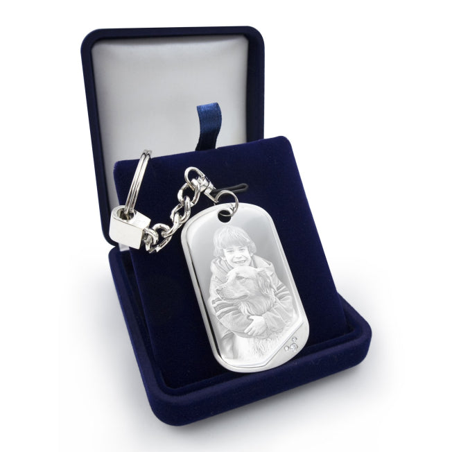 Porte-clés argenté avec plaque gravée d’un enfant et son chien, présenté dans un coffret. Un cadeau personnalisé attendrissant pour immortaliser un lien fort.