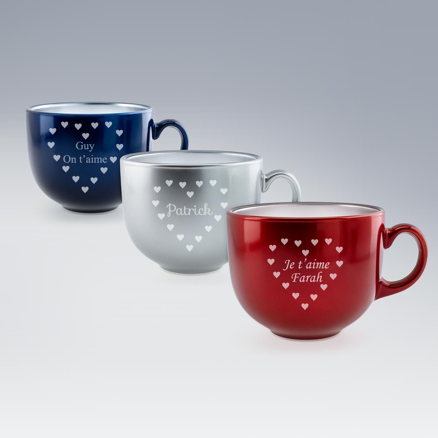 Trois tasses Jumbo alignées : rouge avec "Je t’aime Farah", argent avec "Patrick" et bleue avec "Guy On t’aime", toutes ornées de cœurs gravés. Présentation sur fond lumineux pour mettre en valeur les motifs.