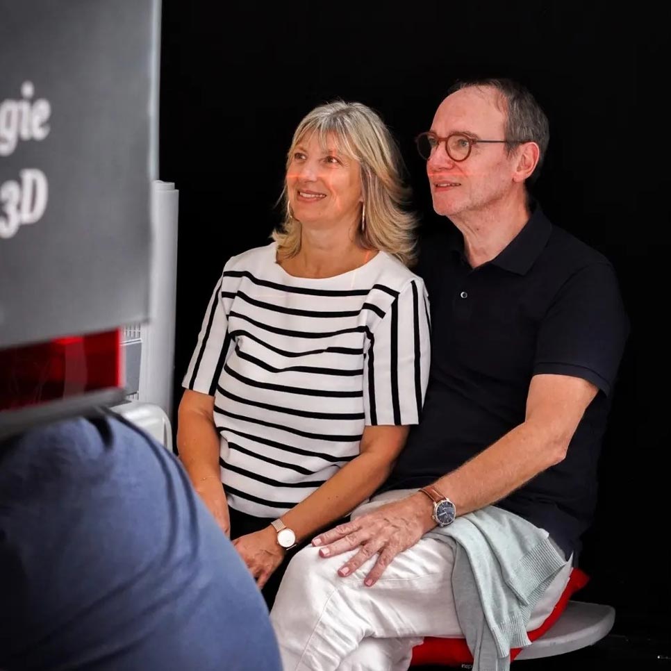 Un couple se fait scanner en 3D à la boutique Zephyr Paris pour une gravure personnalisée dans un bloc de verre, souvenir unique gravé sur place.