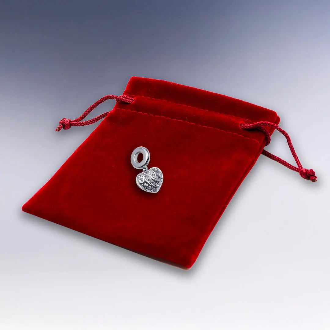 Charm Cœur 3D Argenté sur pochette suédine rouge – Ce charm raffiné en forme de cœur gravé apporte une note sentimentale et brillante à votre bracelet personnalisé.
