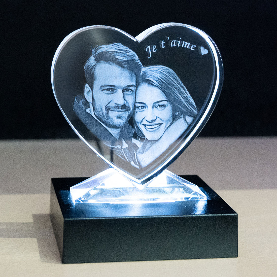 Cœur en verre avec photo de couple gravée en 2D et socle LED lumineux. Cadeau personnalisé parfait pour dire “Je t’aime” avec élégance.