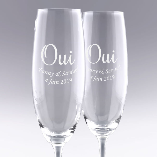 Duo de flûtes à champagne gravées "OUI" avec prénoms et date. Cadeau de mariage personnalisé parfait pour célébrer l’union des mariés avec élégance.