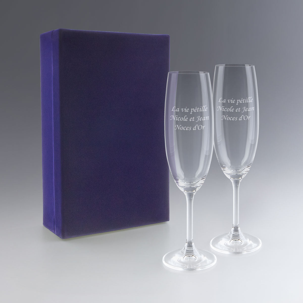 Coffret bleu contenant deux flûtes à champagne gravées avec date et prénoms. Cadeau mariage personnalisé et élégant pour un souvenir inoubliable.