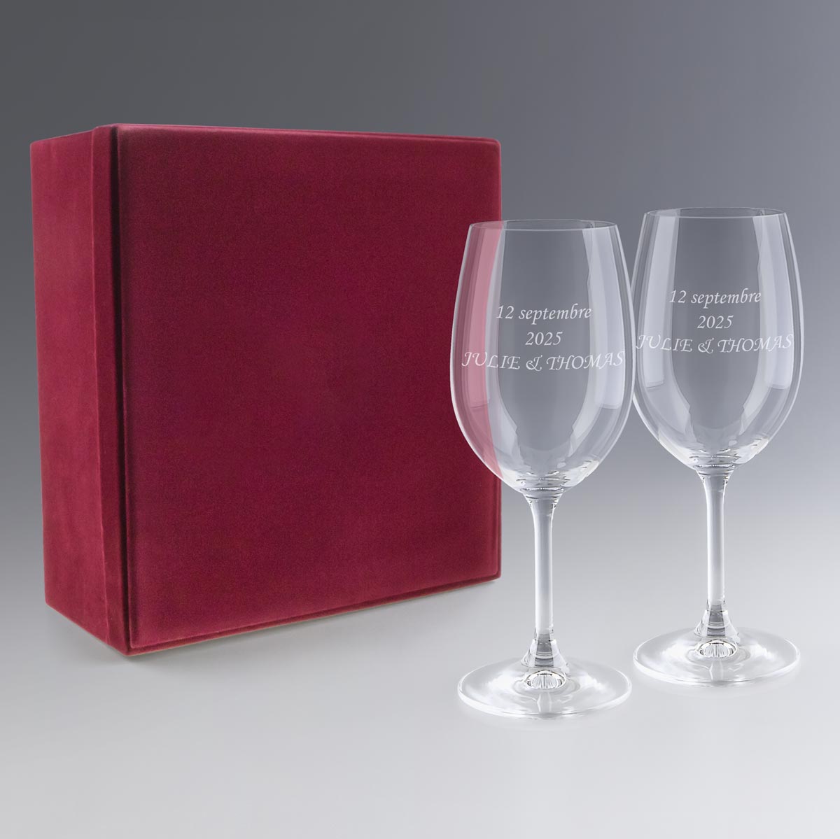 Coffret rouge avec deux verres à vin gravés au laser portant l'inscription personnalisée "12 septembre 2025, JULIE & THOMAS", présenté en vue studio sur fond clair.