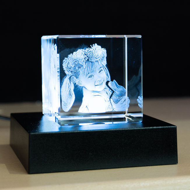 Bloc en verre 6 cm éclairé par LED, gravé avec la photo d’une petite fille souriante. Gravure laser fine, idée cadeau personnalisée émotive.