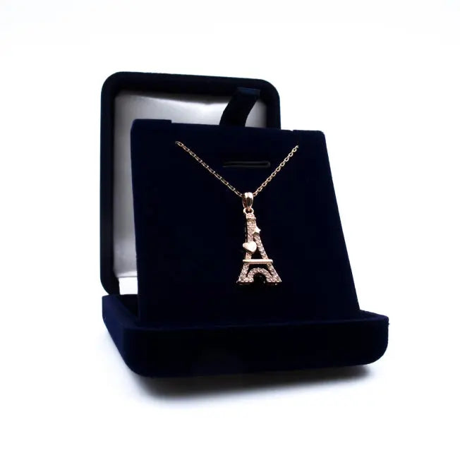 Pendentif Tour Eiffel Cœur en métal doré rose orné de cristaux brillants, présenté dans un écrin bleu nuit personnalisable.
