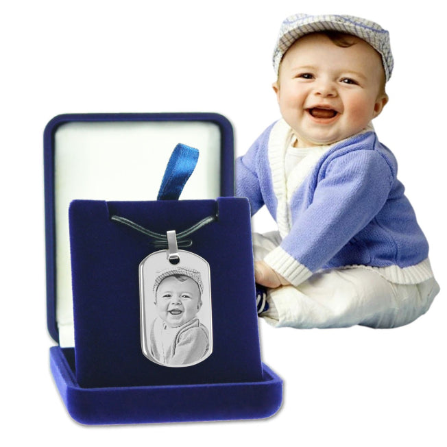 Pendentif argenté avec gravure photo d’un bébé souriant, dans un écrin velours. Un bijou souvenir à personnaliser.