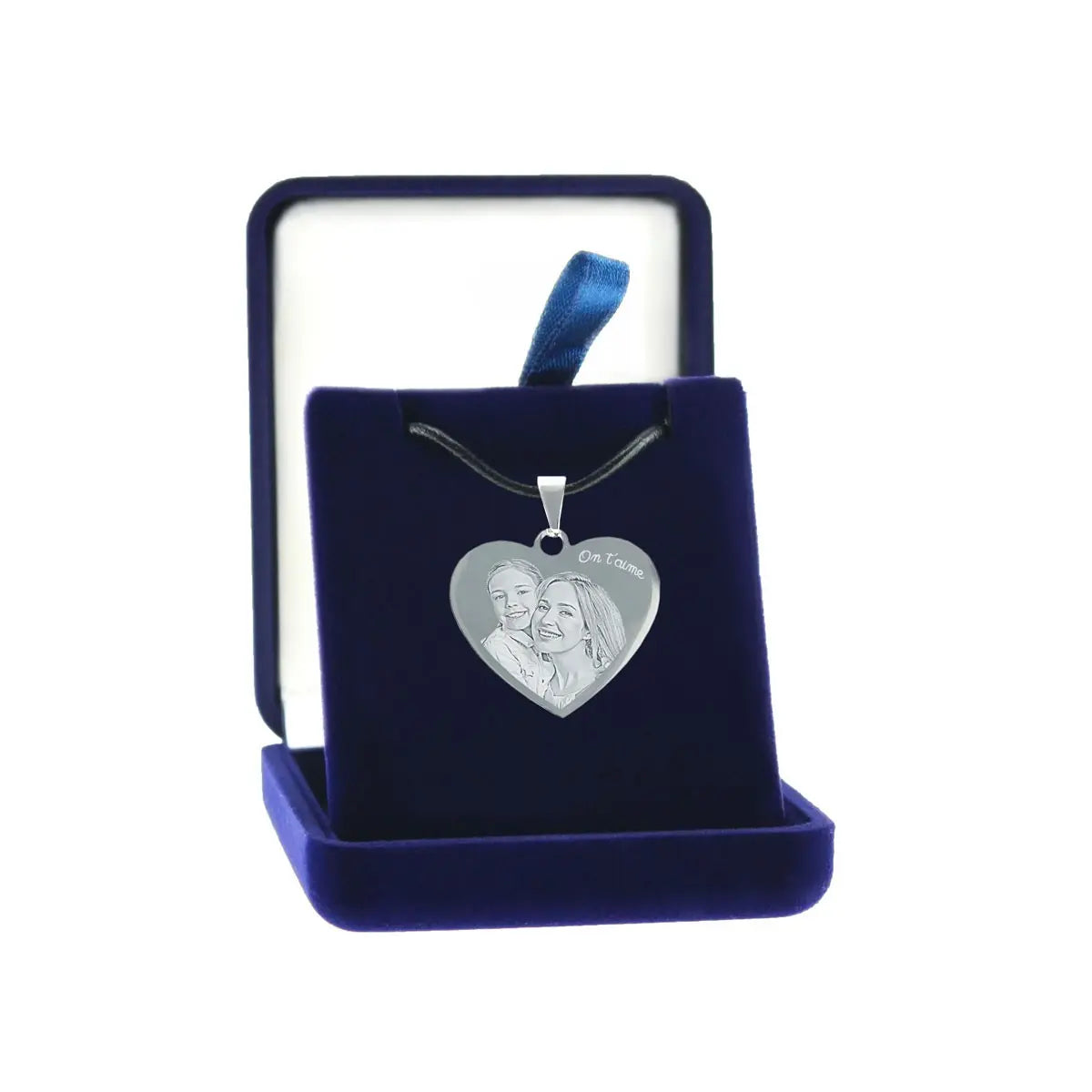 Pendentif cœur gravé avec deux visages et un texte “On t’aime”, présenté dans un écrin bleu nuit. Cadeau personnalisé et émouvant.