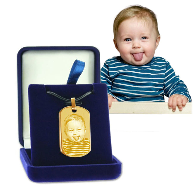 Pendentif doré avec gravure d’un bébé amusant. Présenté dans un écrin bleu, parfait pour un cadeau original et personnalisé.