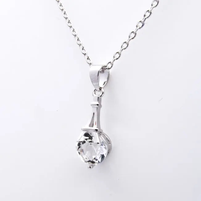 Zoom sur pendentif argenté avec cristal Swarovski® serti à la base d’une Tour Eiffel stylisée. Idéal pour un cadeau symbolique et élégant.