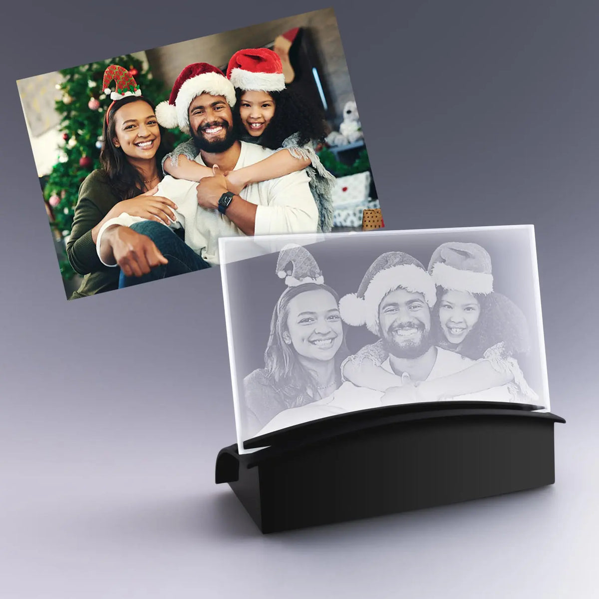 Gravure 2D personnalisée sur plaque en verre horizontale avec socle lumineux LED, représentant une famille joyeuse en tenue de Noël devant le sapin.