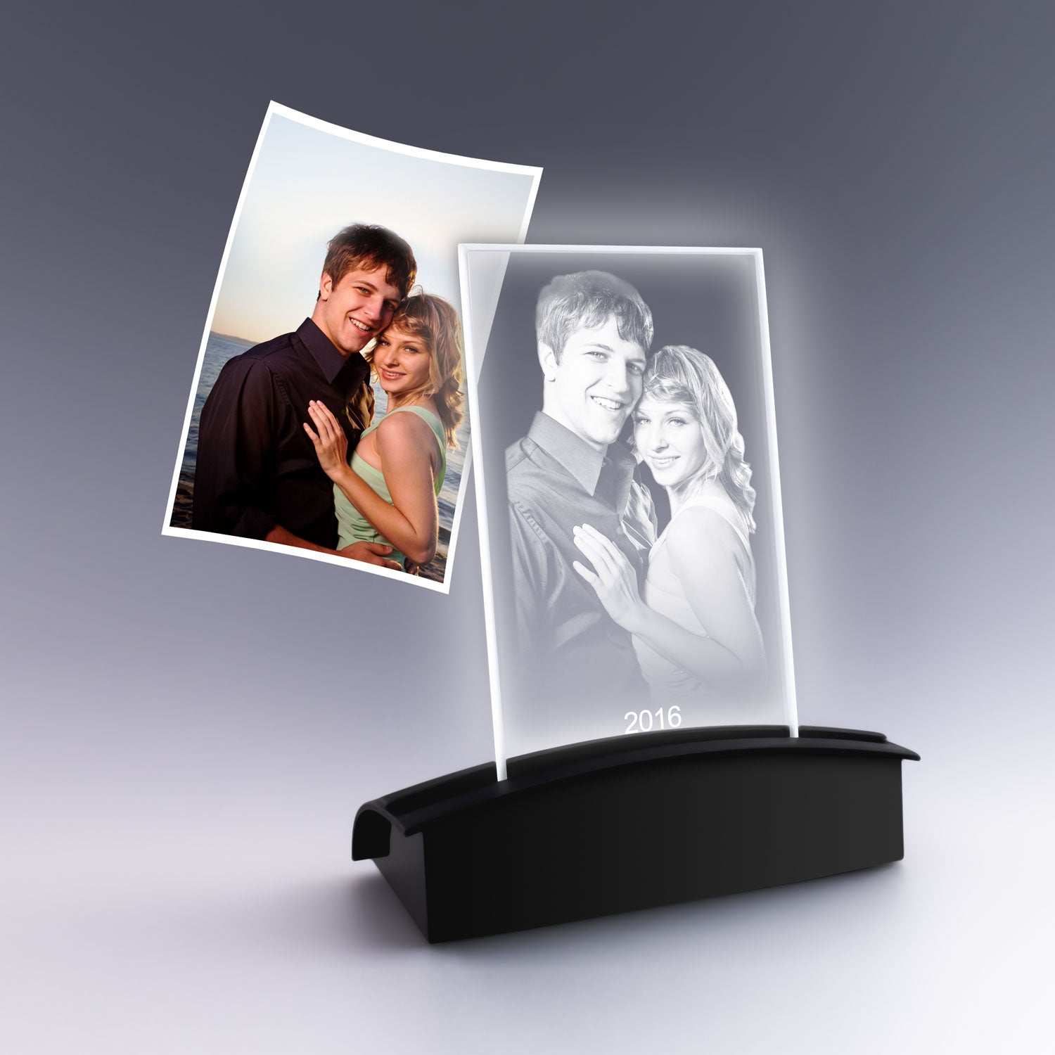 Gravure 2D personnalisée d’un couple enlacé sur plaque photo verticale en verre, posée sur un socle lumineux noir, cadeau romantique élégant.
