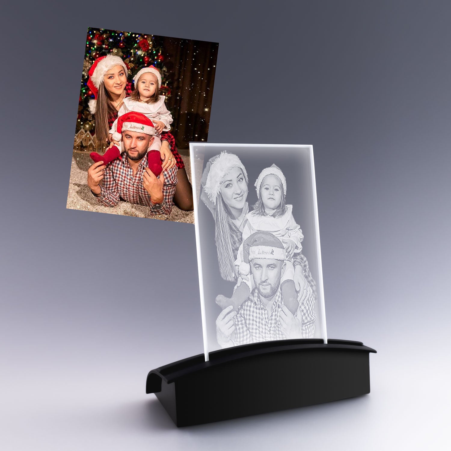 Plaque photo verticale en verre avec gravure 2D de Noël, représentant une famille en habits de fête sur socle lumineux noir, idée cadeau personnalisée.