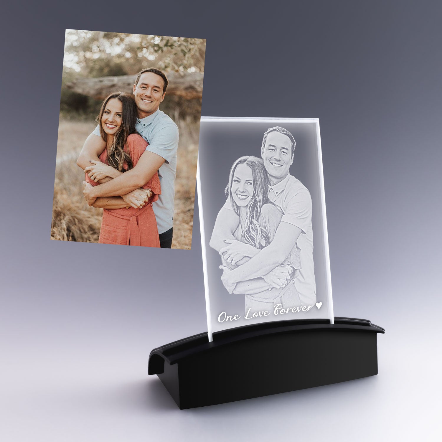 Gravure 2D personnalisée d’un couple enlacé sur plaque photo verticale en verre, posée sur un socle lumineux noir, cadeau romantique élégant.
