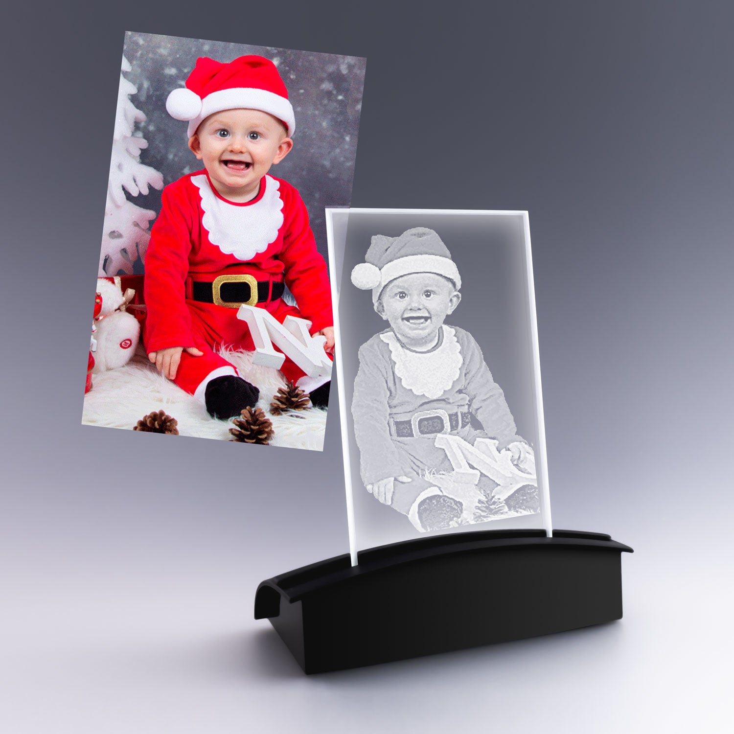 Plaque en verre verticale avec gravure 2D d’un bébé déguisé en Père Noël, installée sur un socle lumineux, cadeau personnalisé pour les fêtes.