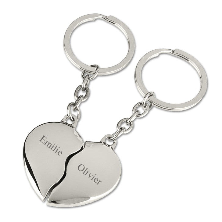 Porte-clés cœur argenté en deux moitiés distinctes avec les prénoms "Émilie" et "Olivier", gravés en finesse sur métal poli pour un cadeau unique et sentimental.