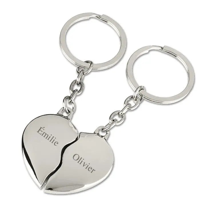 Porte-clés cœur argenté en deux moitiés distinctes avec les prénoms "Émilie" et "Olivier", gravés en finesse sur métal poli pour un cadeau unique et sentimental.