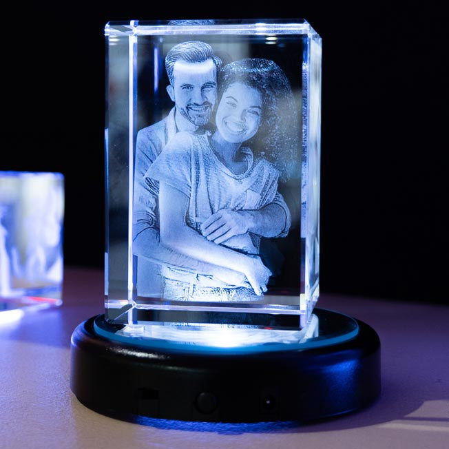 Un couple est gravé en 3D dans un bloc de verre vertical, éclairé par un socle LED. Ce cadeau personnalisé immortalise l’amour avec une gravure lumineuse et élégante.