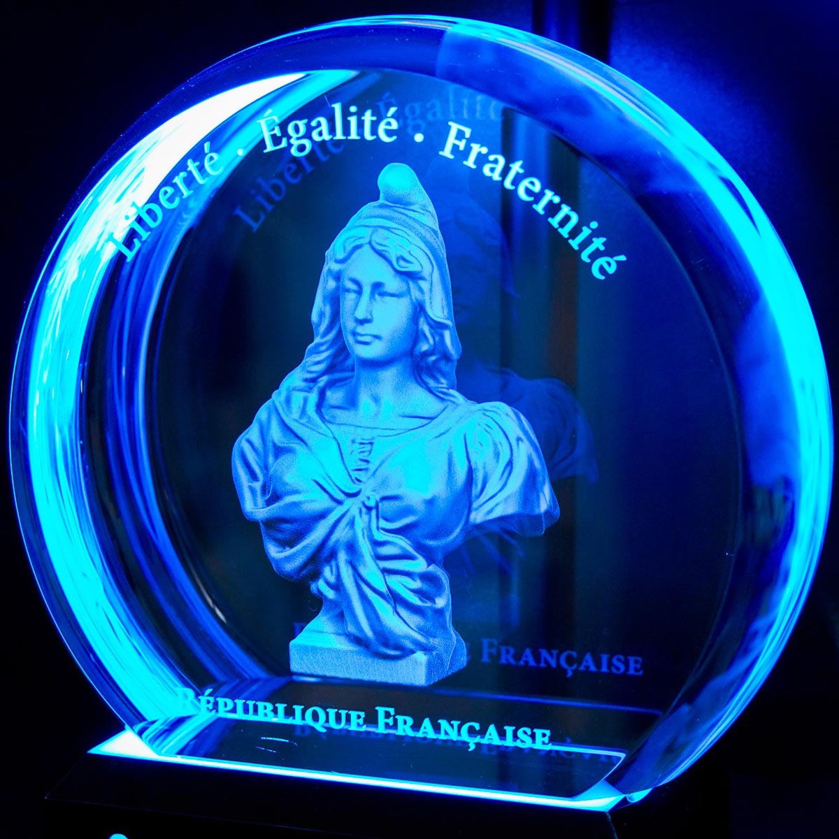 Trophée rond en verre avec gravure 3D de Marianne et inscription « Liberté, Égalité, Fraternité », lumineux pour distinction officielle.