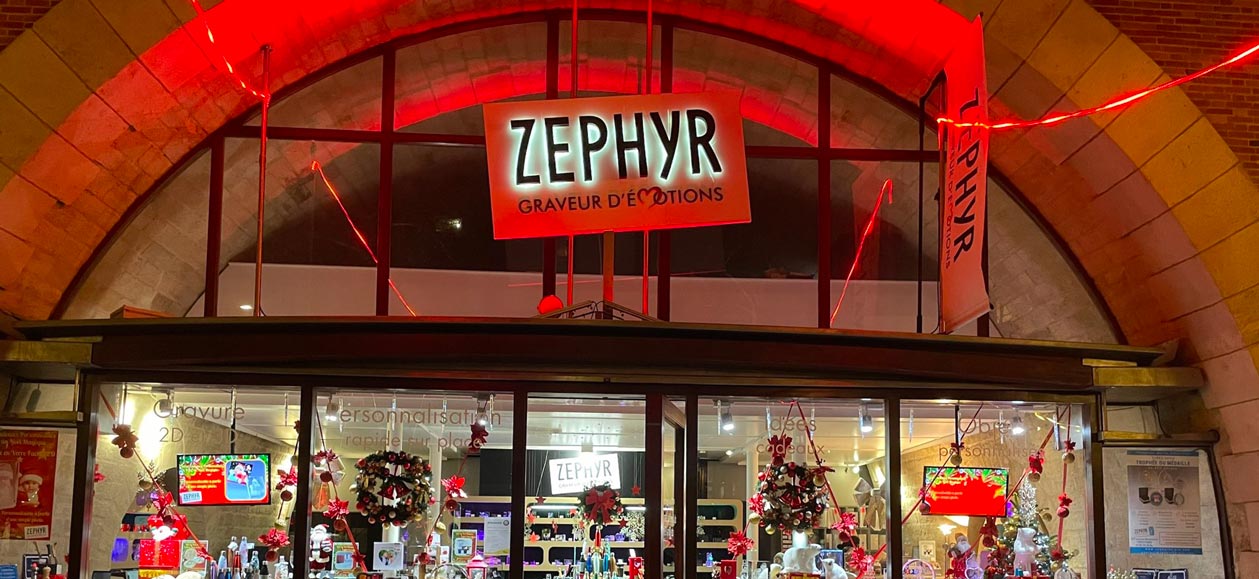 Boutique Zephyr Paris illuminée pour Noël, située au 127 avenue Daumesnil sous le Viaduc des Arts. Vitrine décorée de cadeaux personnalisés gravés, idées originales à personnaliser sur place ou en ligne.
