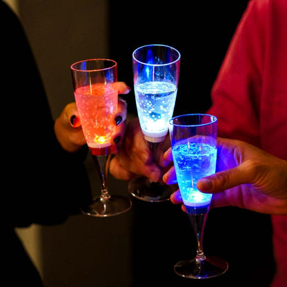 Flûtes lumineuses à LED tenues en main. Idéales pour un toast de fête ou un événement de fin d’année original.
