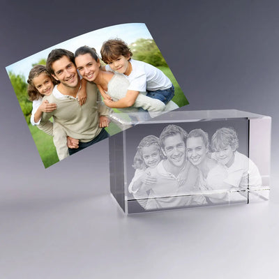 Bloc en verre horizontal de 12 cm gravé en 3D avec le portrait d’une famille de quatre personnes, inspiré de la photo couleur placée en arrière-plan.