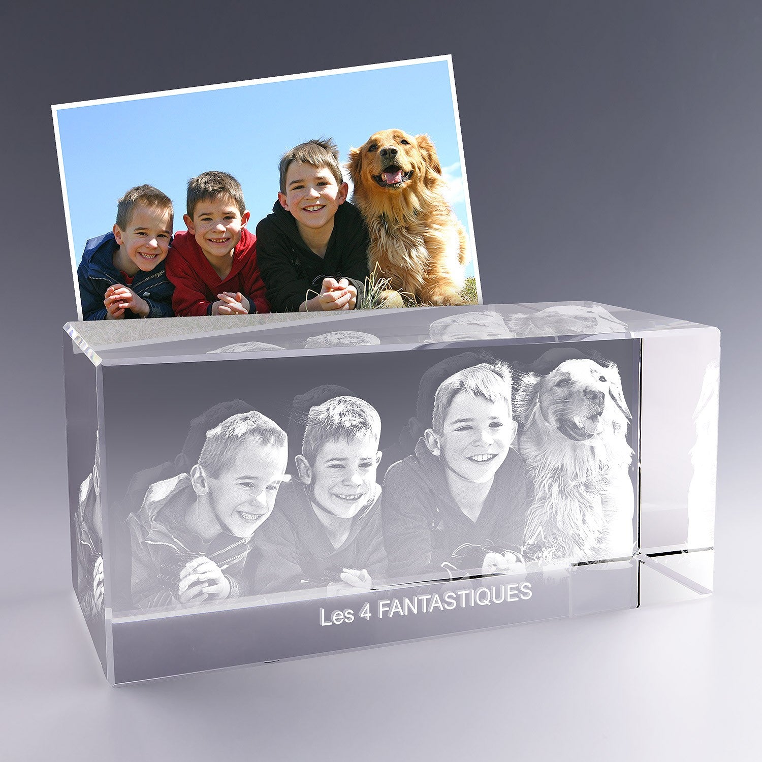 Bloc en verre rectangulaire de 30 cm gravé en 3D avec le portrait de trois enfants et d’un chien, accompagné du texte “Les 4 FANTASTIQUES”, d’après une photo.