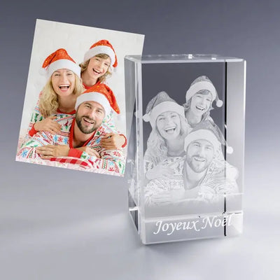 Bloc en verre vertical personnalisé représentant une famille souriante en tenues de Noël avec bonnets rouges. La photo gravée montre trois visages heureux superposés, accompagnés de la mention "Joyeux Noël", parfaite pour un souvenir festif et chaleureux.
