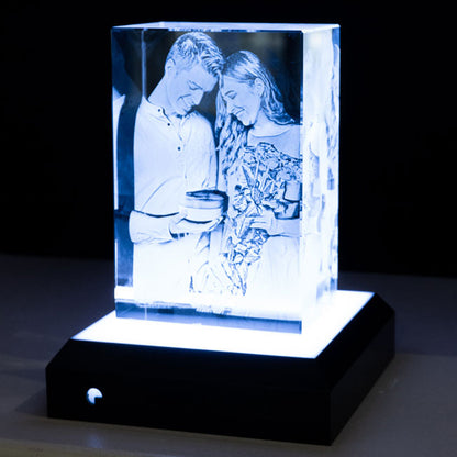 Bloc en verre cristallin avec éclairage LED intégré, représentant un couple heureux lors d’un échange de cadeaux. La gravure 3D en haute précision révèle chaque détail de la scène : bouquet de fleurs, boîte offerte et sourires partagés. Un souvenir lumineux et éternel idéal pour la Saint-Valentin ou un anniversaire.