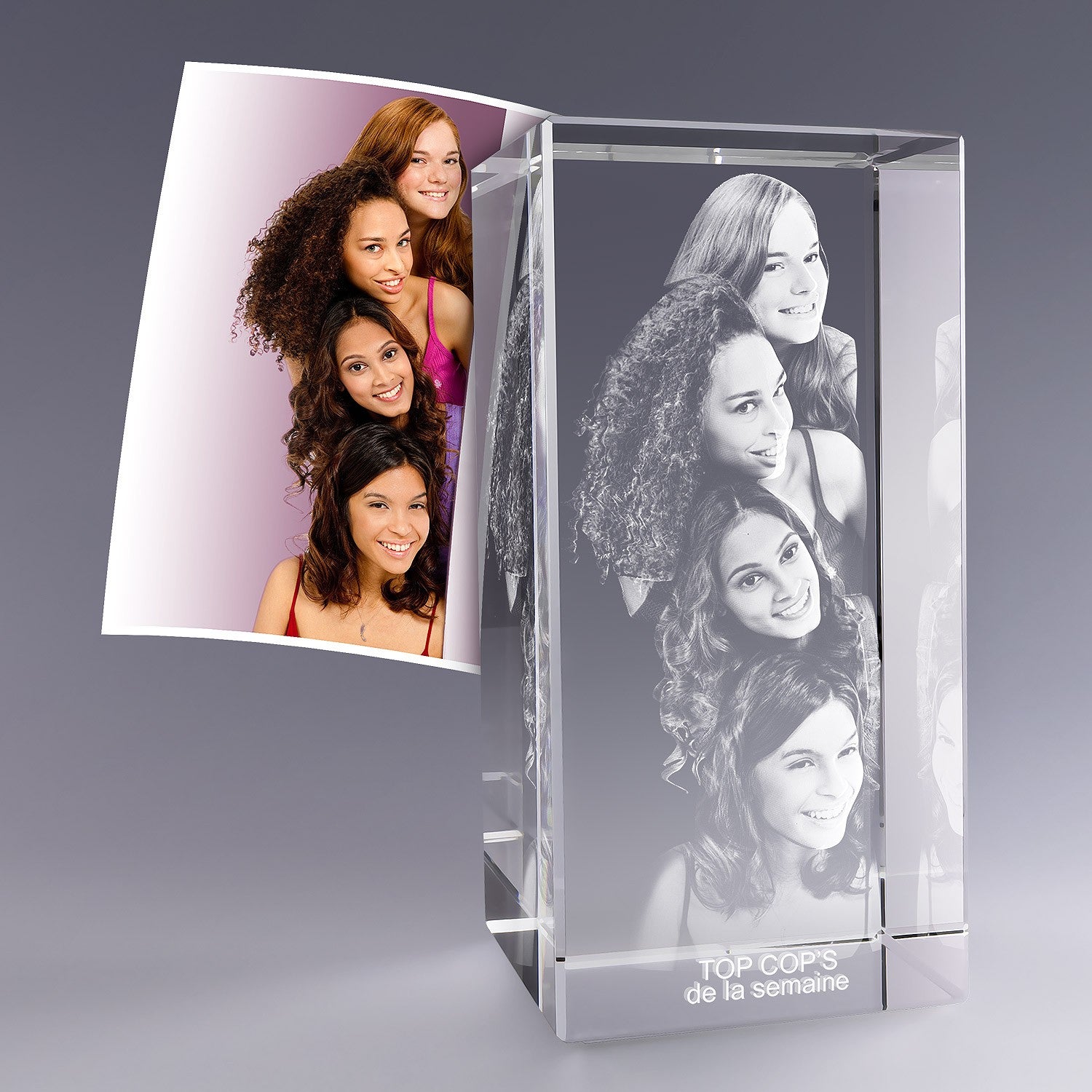 Grand bloc en verre vertical de 30 cm gravé en 3D avec le portrait de cinq amies souriantes et l’inscription “TOP COP’S de la semaine”, d’après une photo.