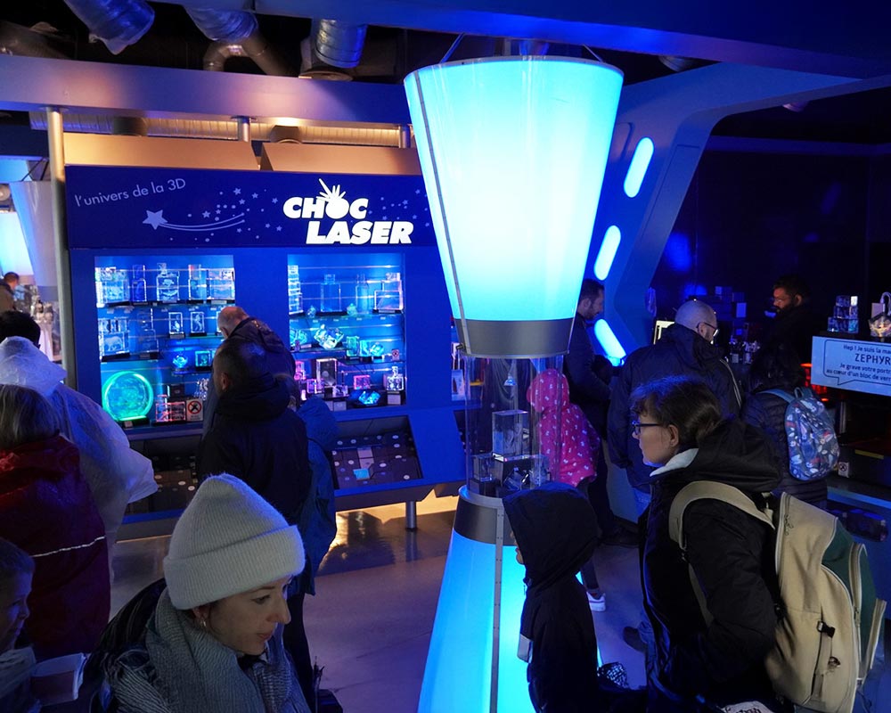 Boutique Choc Laser au Futuroscope présentant des blocs en verre gravés 3D et cadeaux personnalisés pour les visiteurs.