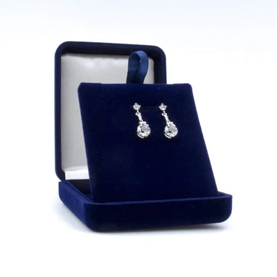 Boucles d’oreilles argentées avec pendentif Tour Eiffel et cristaux Swarovski®, présentées dans un écrin personnalisable pour un cadeau raffiné.