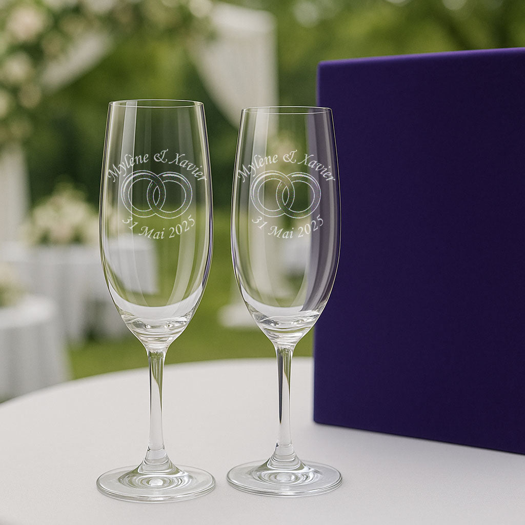 Deux flûtes gravées avec alliances et date, parfaites pour trinquer en plein air lors d’une cérémonie romantique. Cadeau de mariage unique et raffiné.