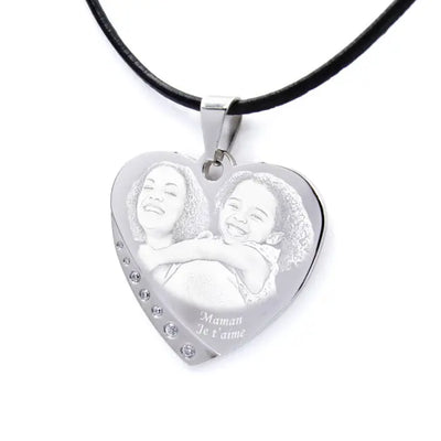 Pendentif cœur gravé avec une maman et sa fille. Message “Maman je t’aime” et finition strass pour un cadeau émouvant.
